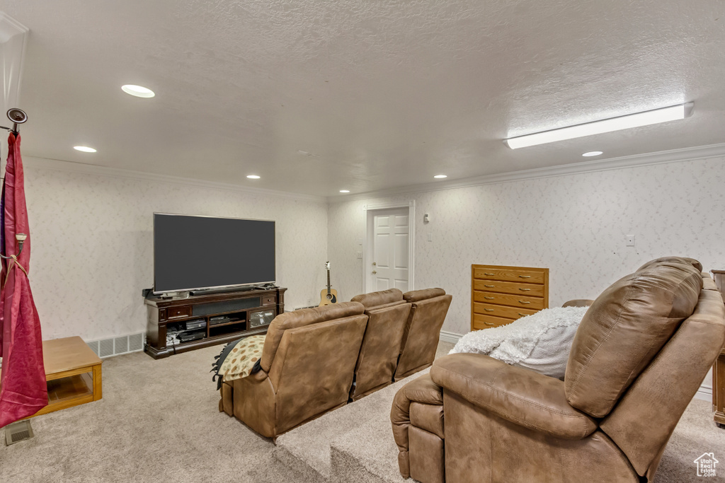 Living area with carpet floors, recessed lighting, crown molding, and a textured ceiling