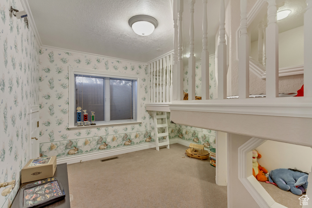 Game room with wallpapered walls, crown molding, a textured ceiling, and carpet flooring