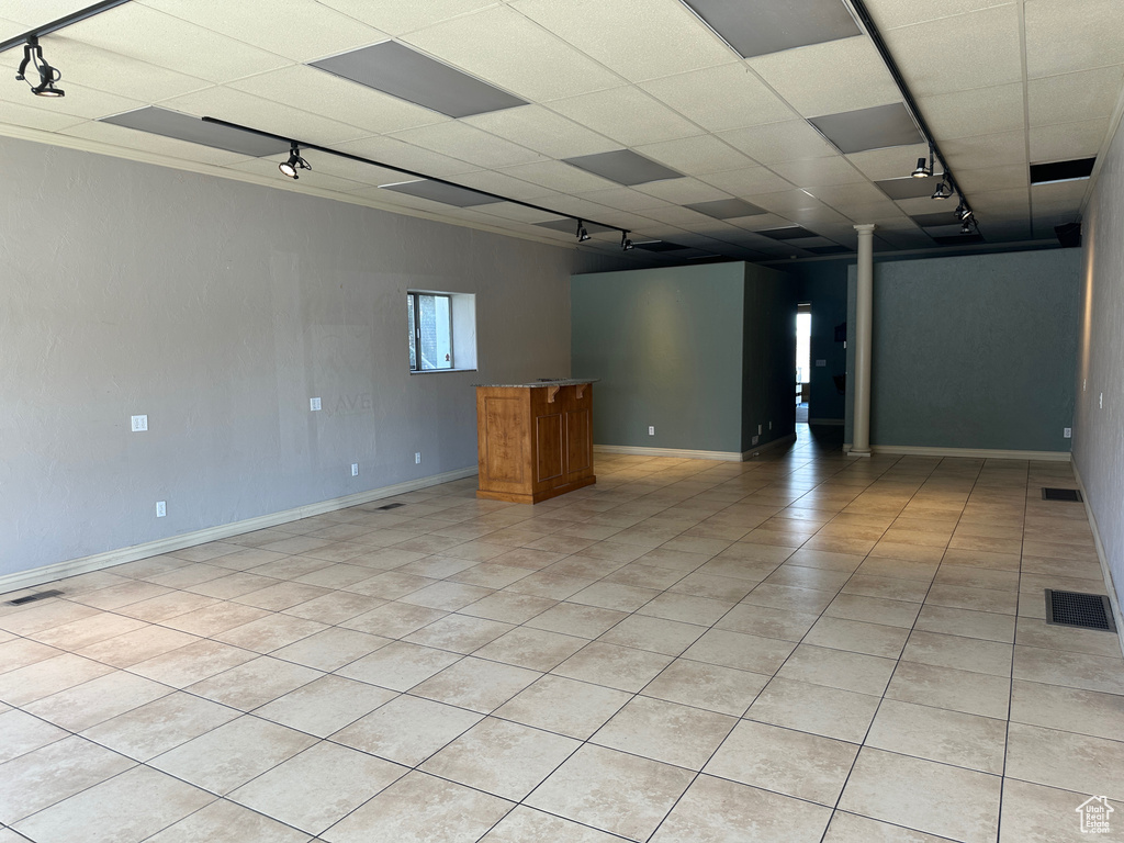 Empty room featuring rail lighting, baseboards, and light tile patterned floors