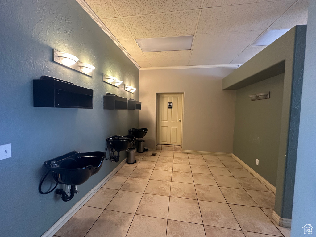 Foyer entrance with light tile patterned floors and crown molding