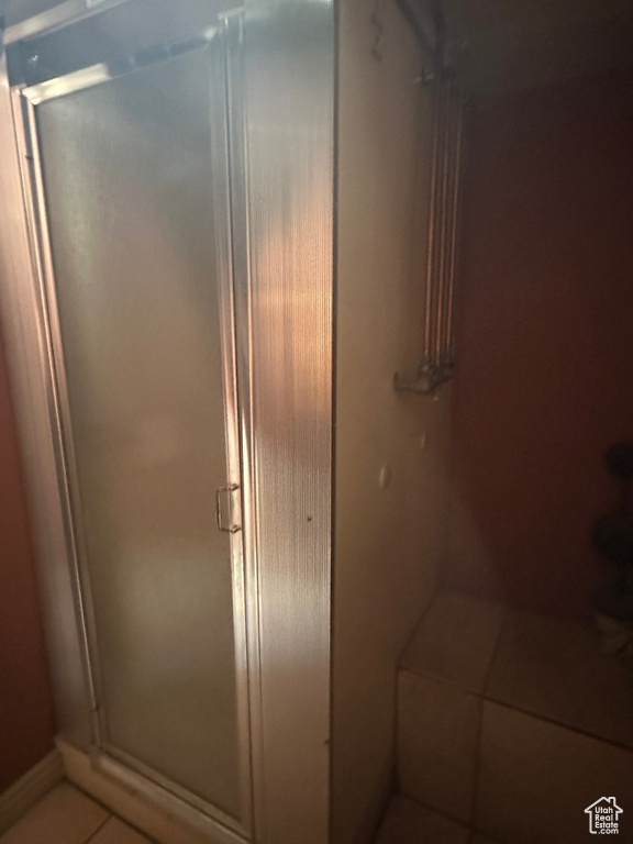 Full bath featuring a shower stall and tile patterned floors