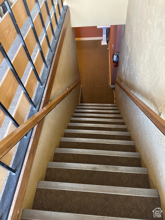 Staircase featuring a textured wall