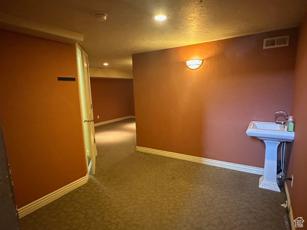 Corridor featuring carpet flooring, recessed lighting, baseboards, and a sink