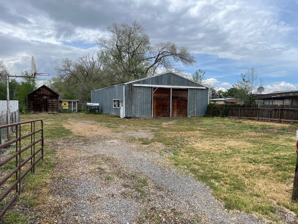 View of pole building with fence and driveway
