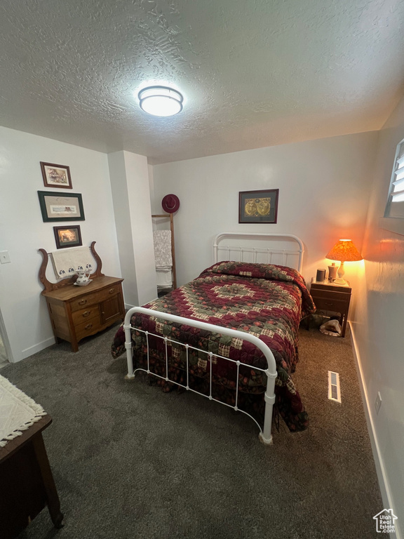 Bedroom featuring a textured ceiling and carpet floors