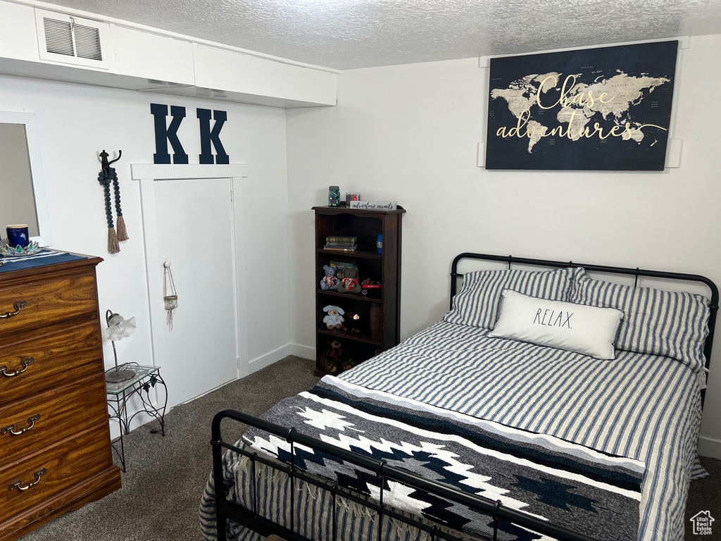 Carpeted bedroom featuring a textured ceiling
