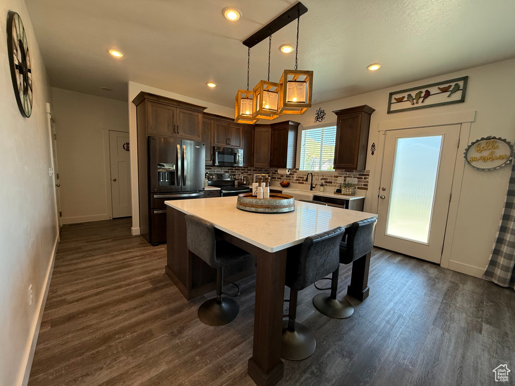 Kitchen featuring black appliances, dark brown cabinets, baseboards, dark wood-style flooring, and recessed lighting