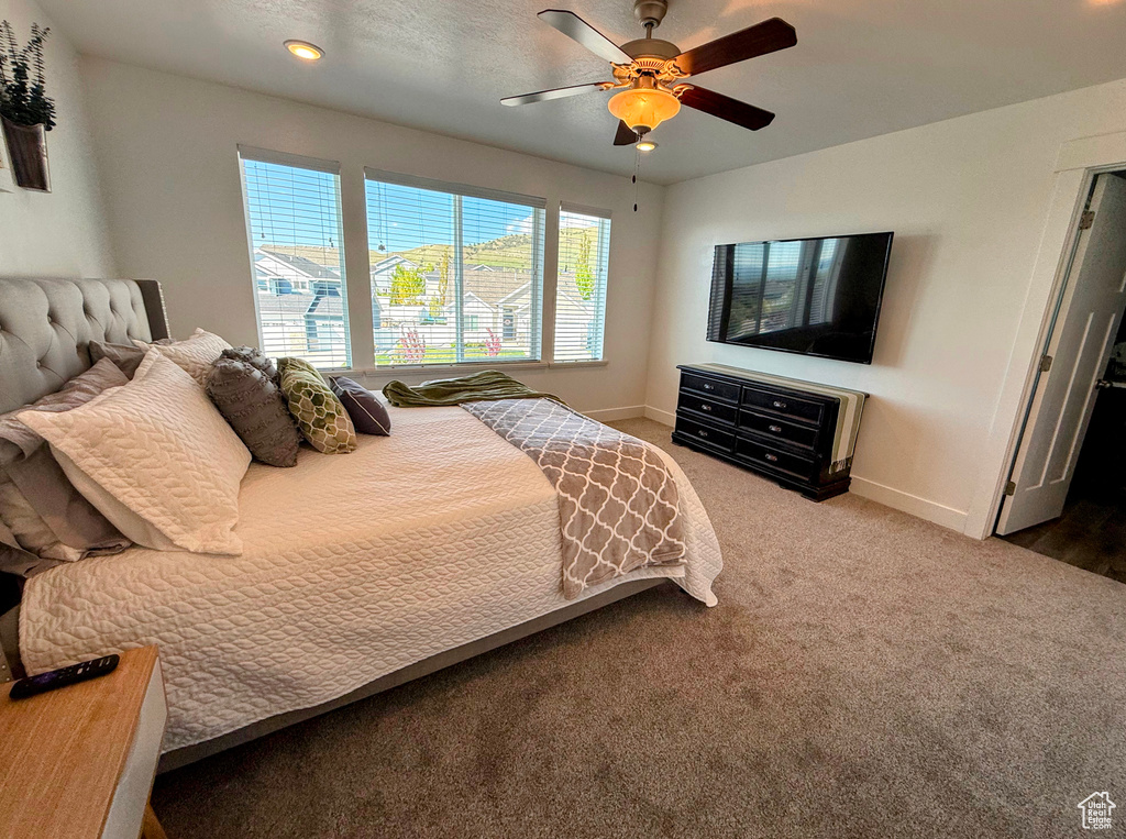 Carpeted bedroom with baseboards and ceiling fan