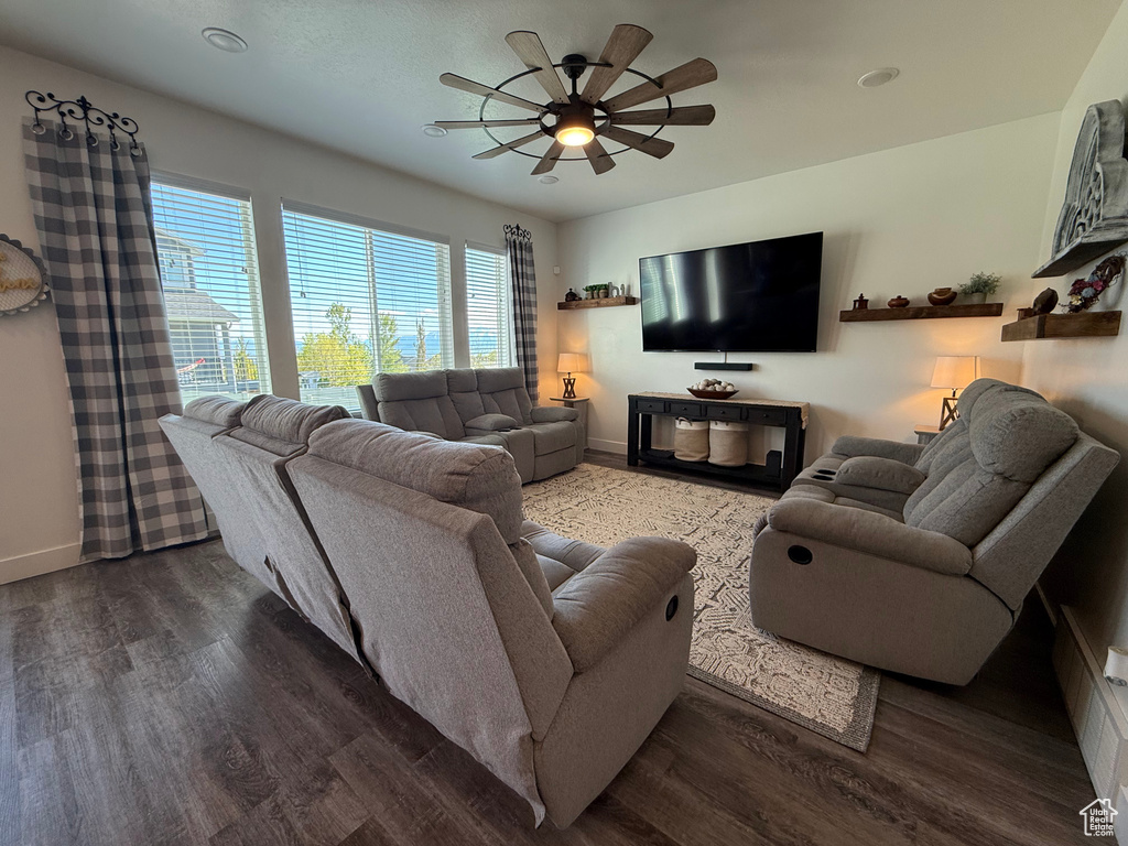 Living room featuring a ceiling fan, baseboards, and wood finished floors
