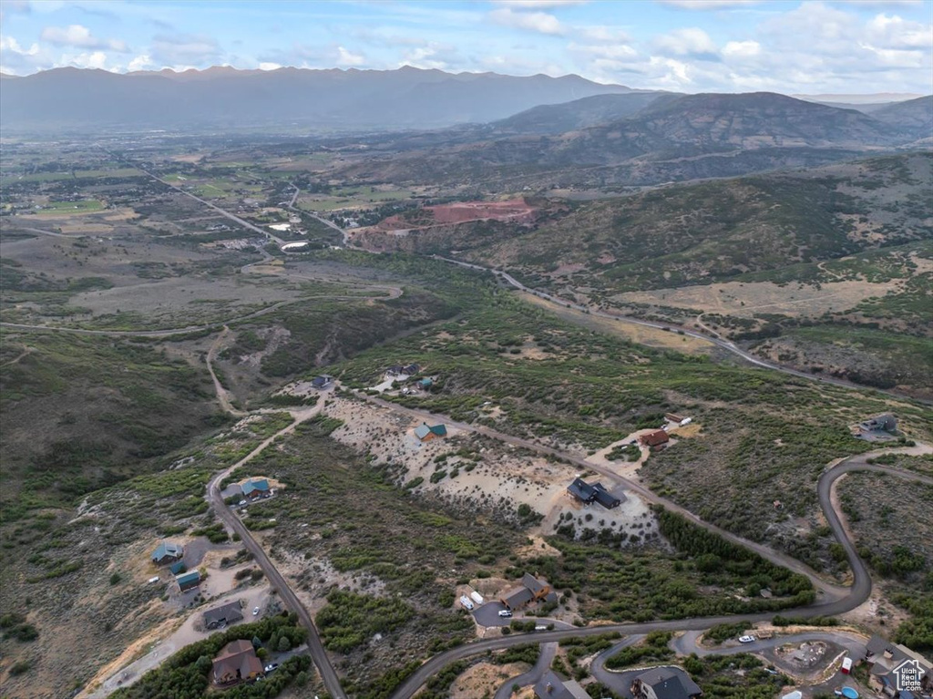Aerial view of property and surrounding area featuring a mountain backdrop