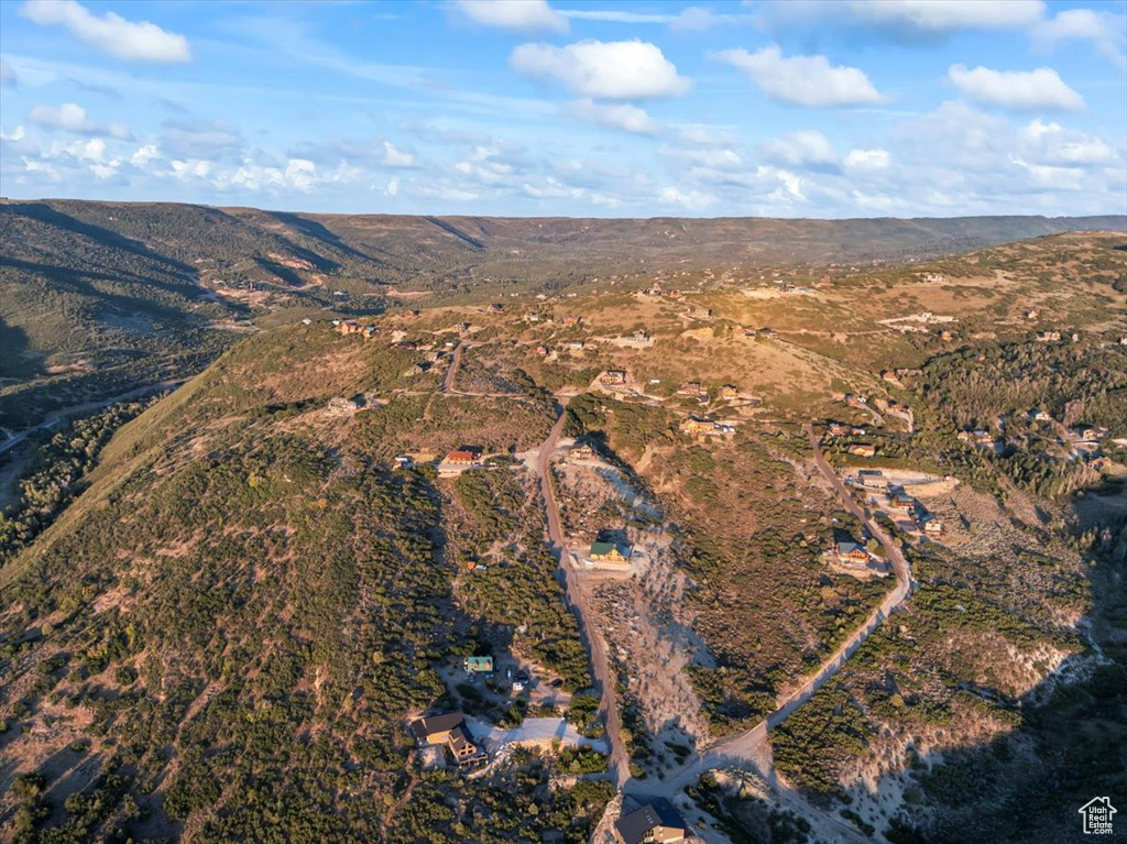Aerial view of property and surrounding area with a mountain backdrop