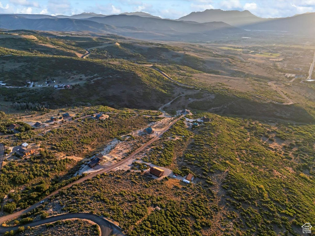 Aerial view of property and surrounding area featuring a mountainous background