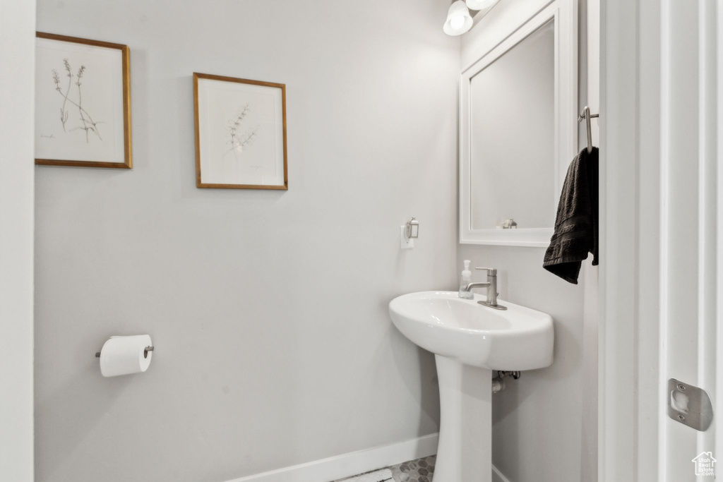 Bathroom featuring baseboards and a sink