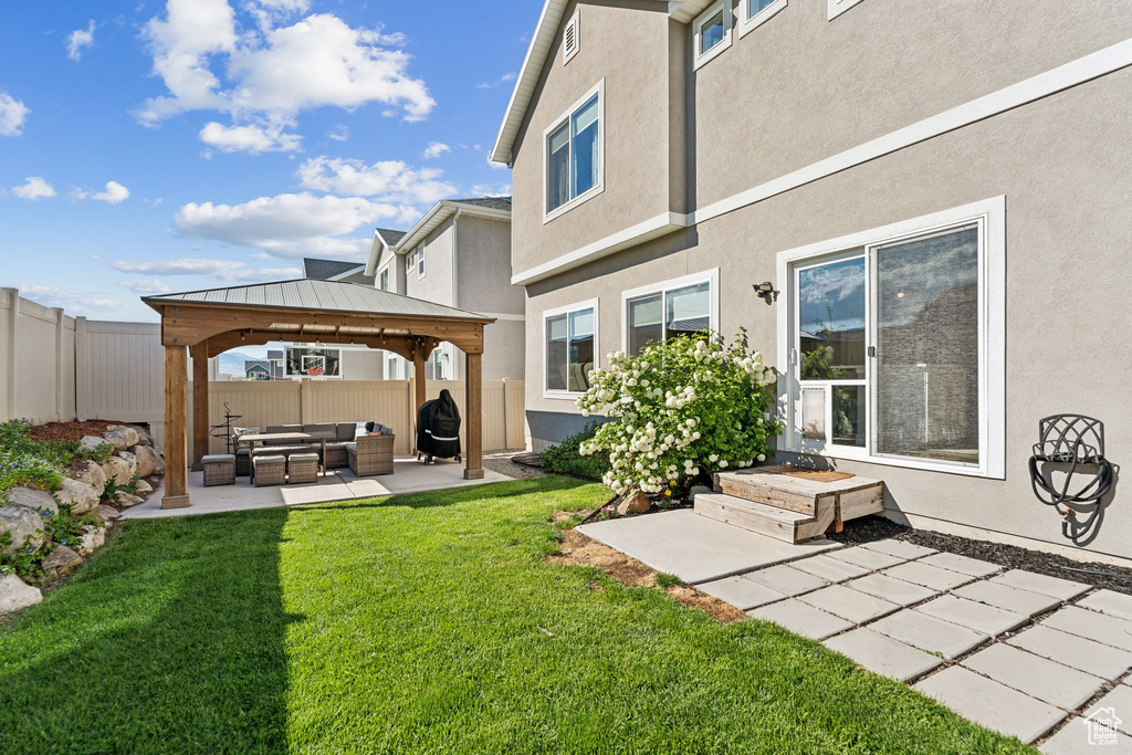 Back of house featuring outdoor lounge area, a gazebo, stucco siding, and a patio