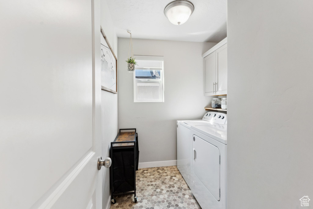 Laundry room with washing machine and clothes dryer, cabinet space, and baseboards