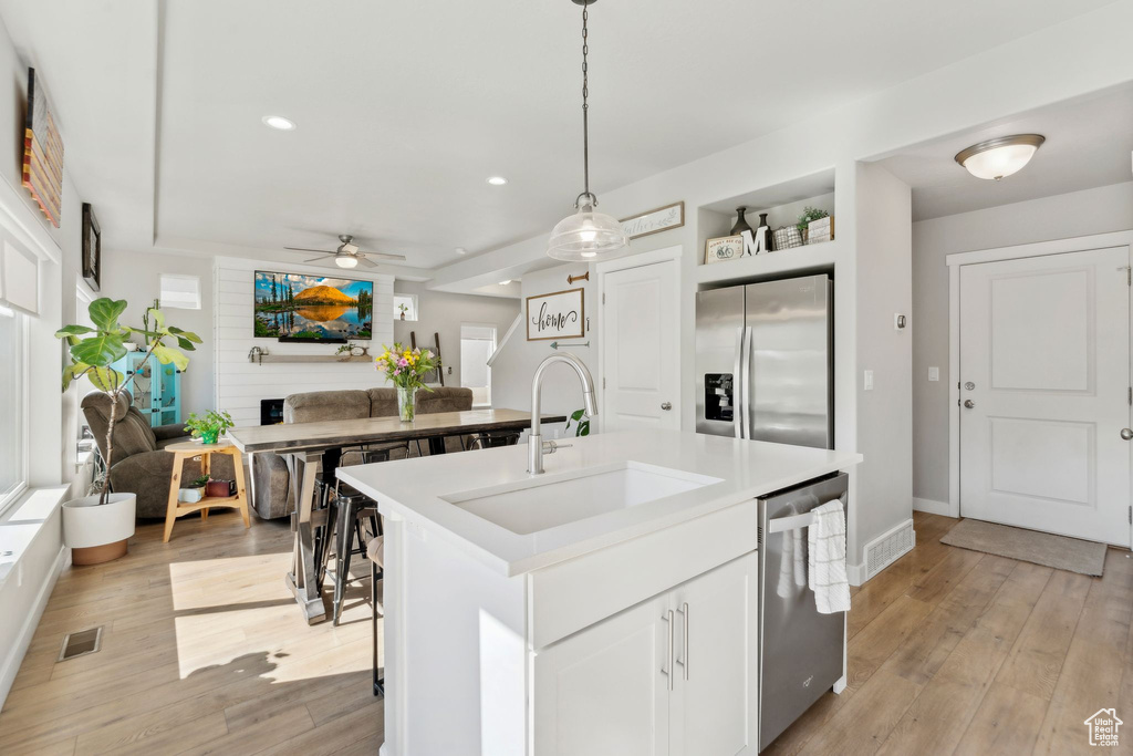 Kitchen with a sink, stainless steel appliances, a ceiling fan, a kitchen island with sink, and recessed lighting