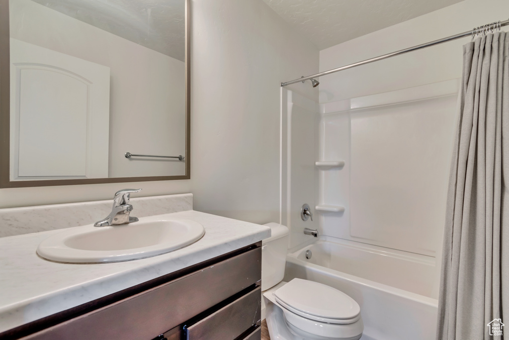 Full bath with vanity, toilet, and shower / tub combo