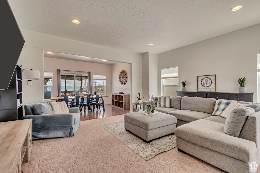 Carpeted living area featuring recessed lighting and a textured ceiling