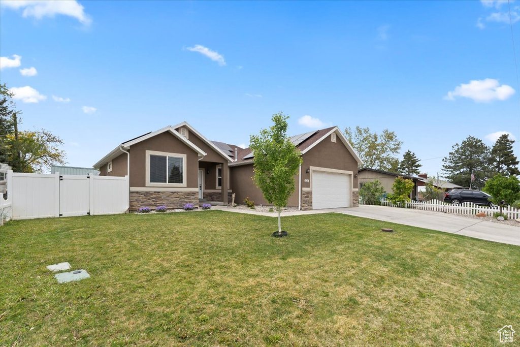Single story home with stucco siding, stone siding, concrete driveway, and a gate