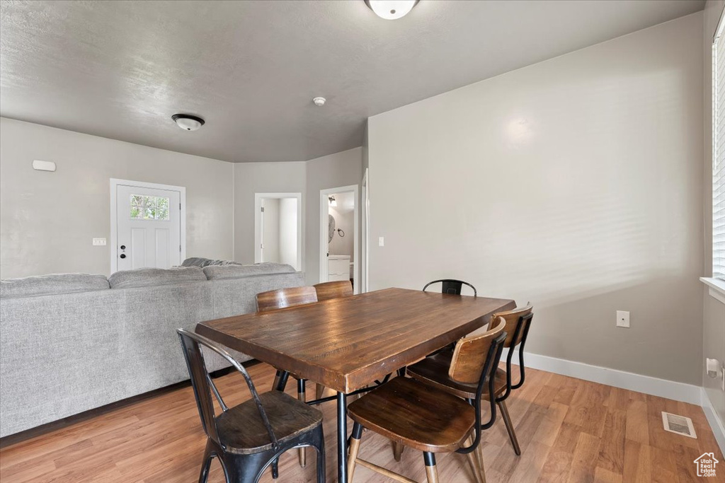Dining area with light wood-type flooring and baseboards