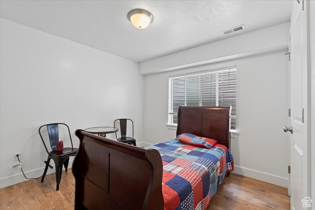 Bedroom with wood finished floors and baseboards