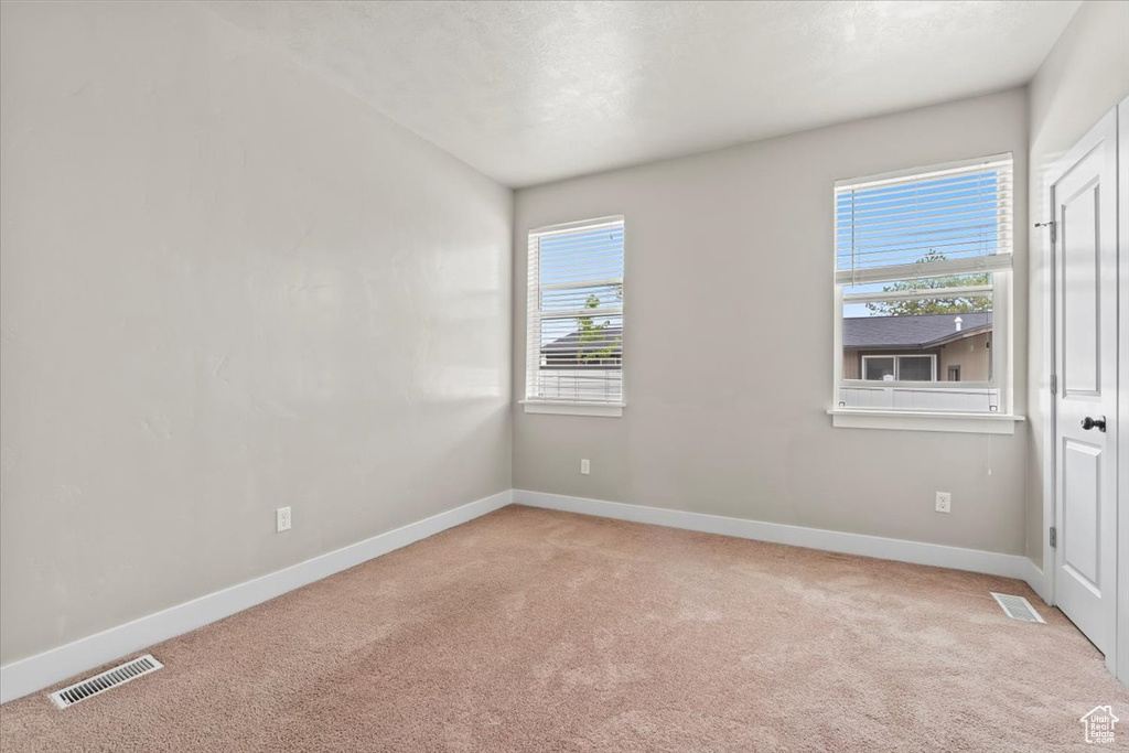 Carpeted empty room featuring baseboards