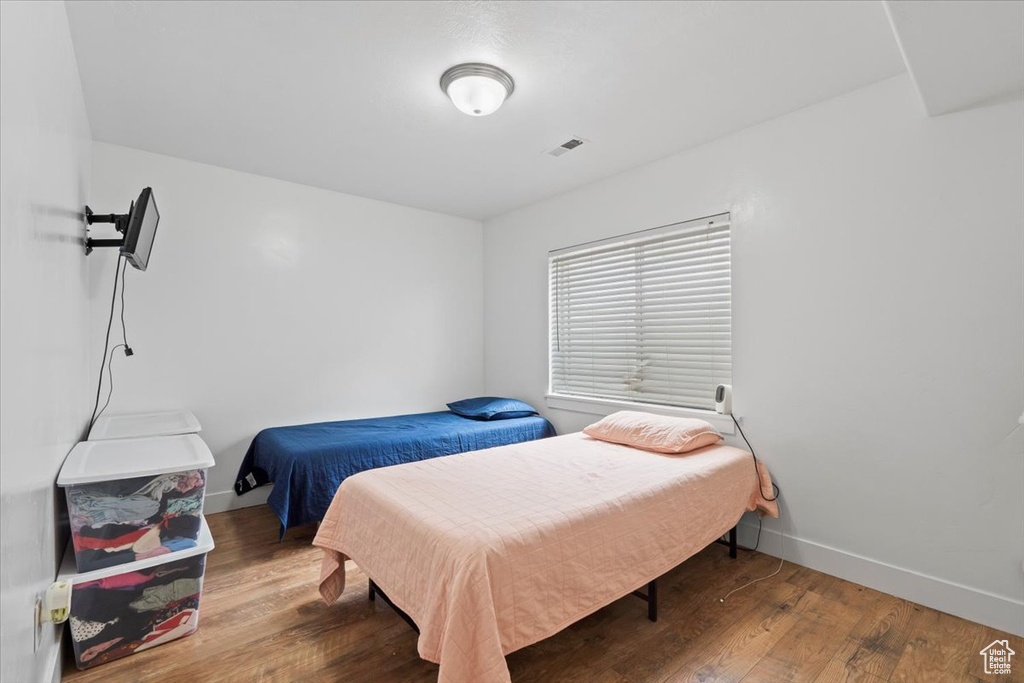 Bedroom with wood finished floors and baseboards