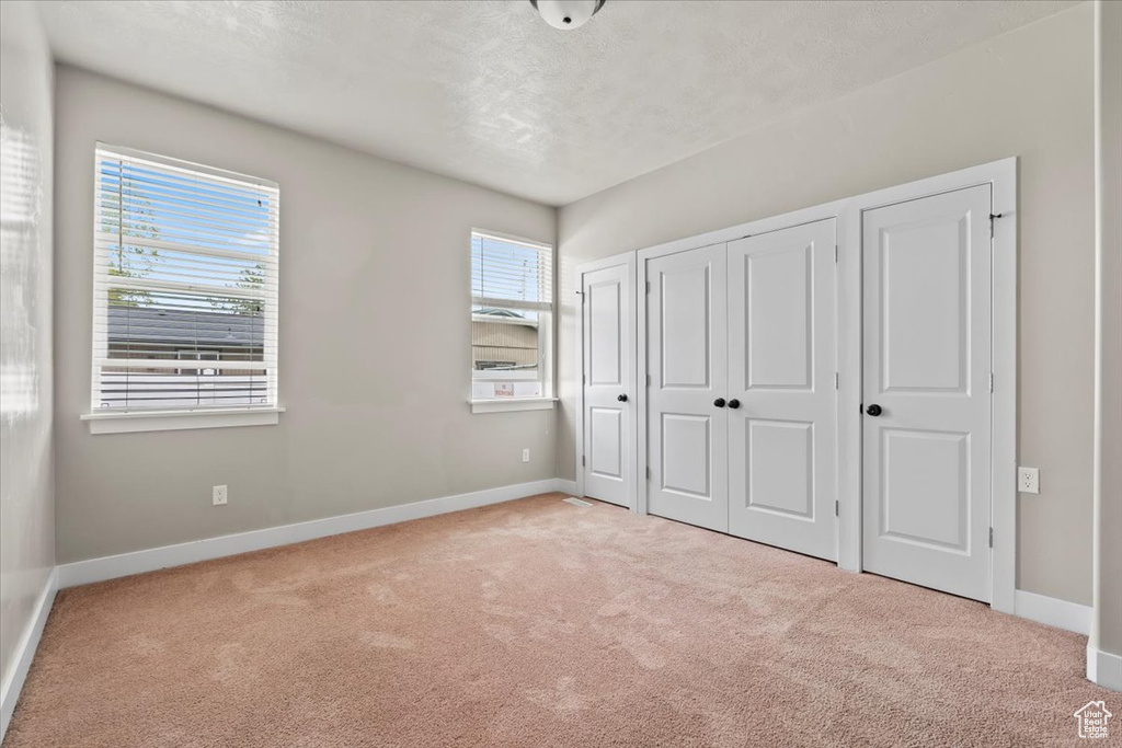 Unfurnished bedroom featuring carpet and baseboards