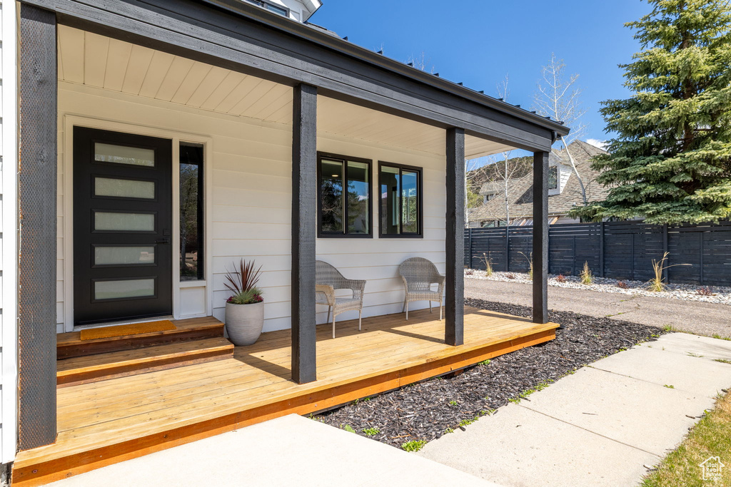 Doorway to property with fence and covered porch