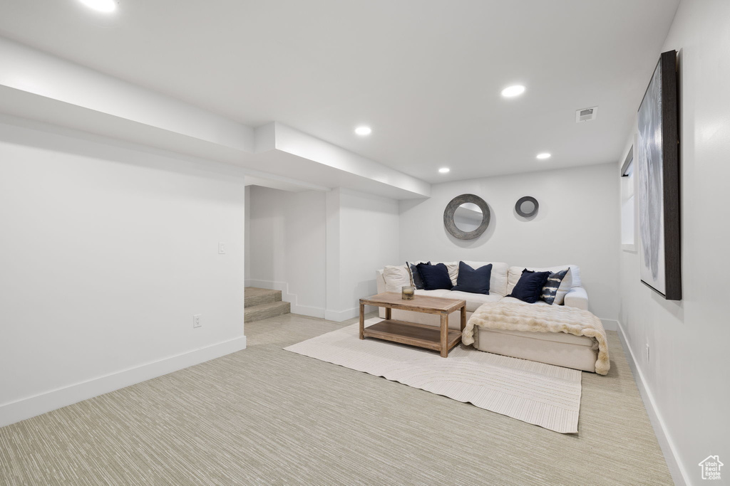 Living area with light carpet, recessed lighting, baseboards, and stairs