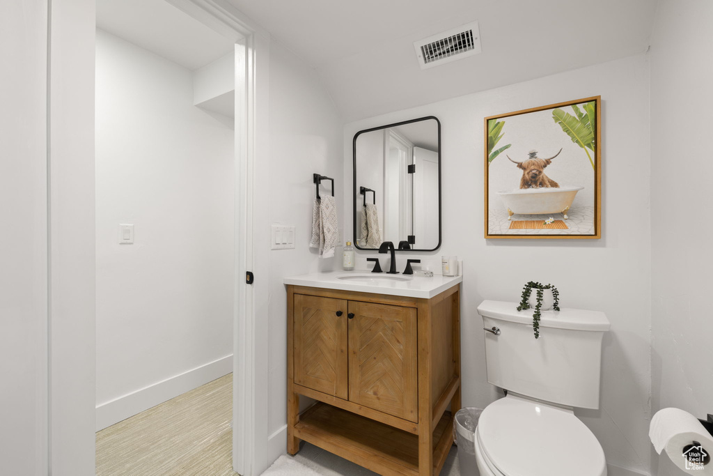 Half bath with vanity, toilet, and baseboards