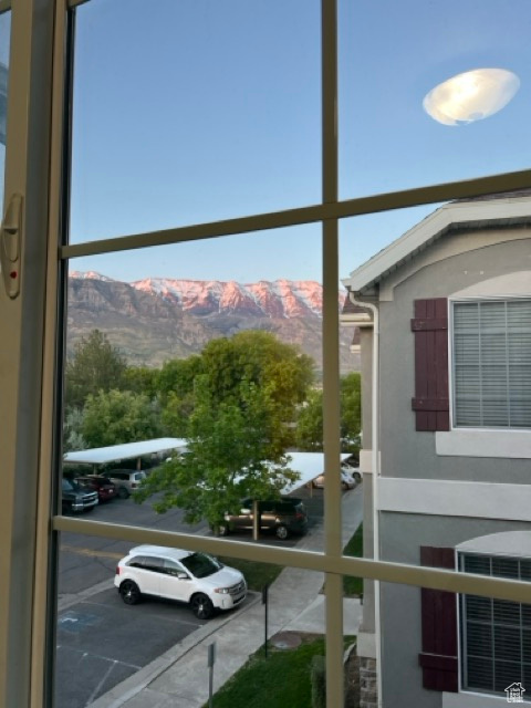 Exterior space featuring stucco siding, a mountain view, and a parking lot