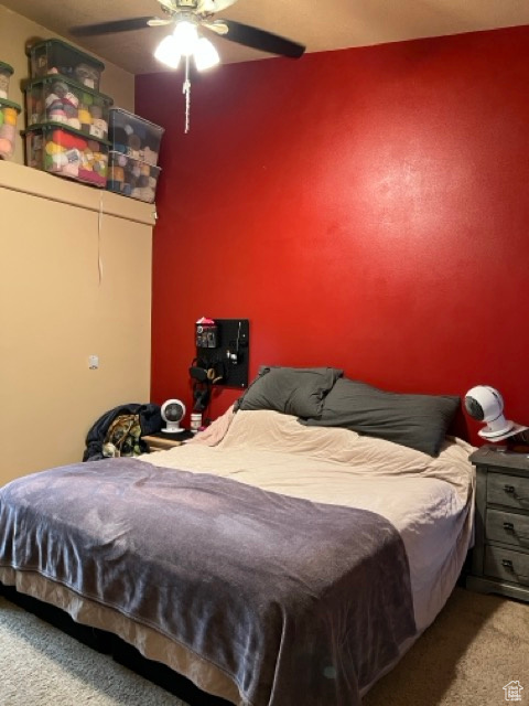 Carpeted bedroom with a ceiling fan