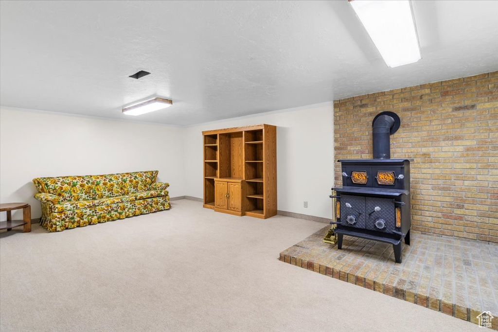 Carpeted living area with a wood stove and baseboards