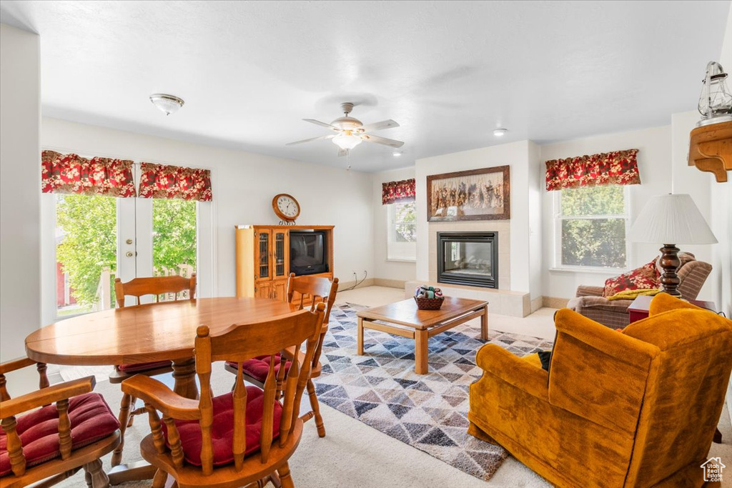 Carpeted living room with a tiled fireplace and a ceiling fan