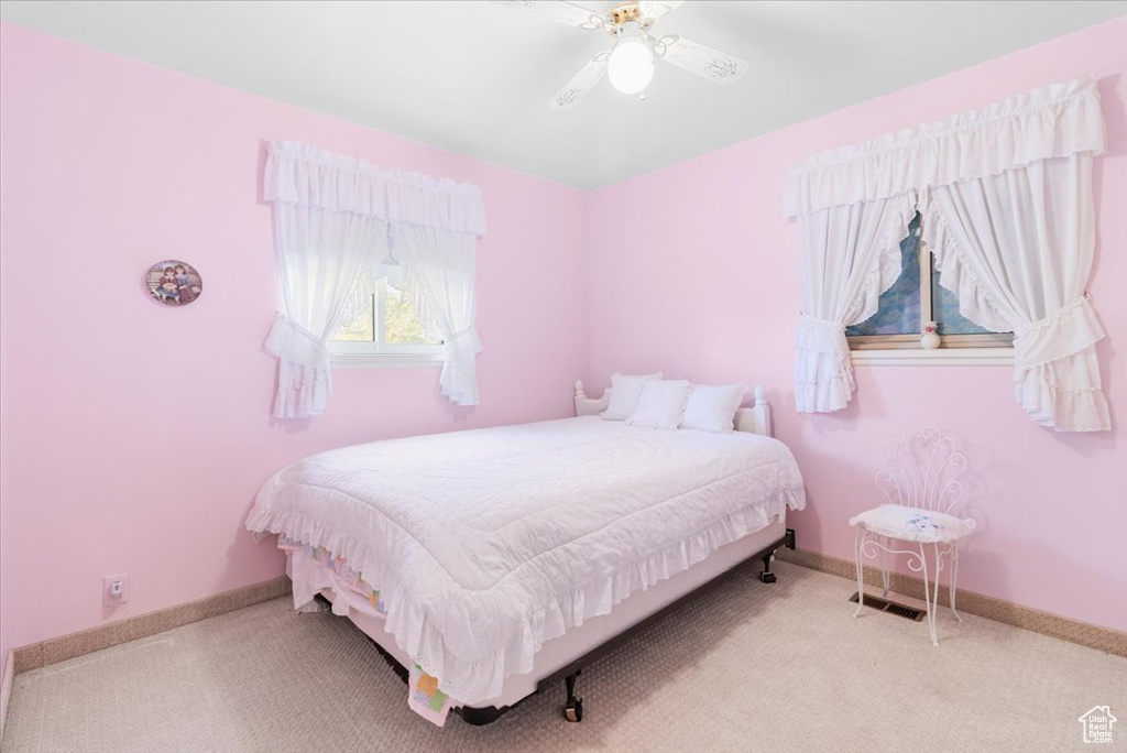 Carpeted bedroom featuring baseboards and ceiling fan