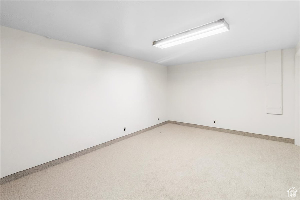 Unfurnished room with light colored carpet and baseboards
