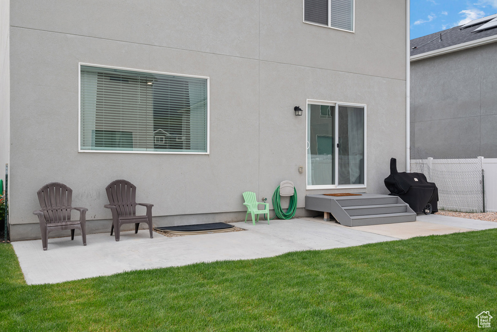 Rear view of house with a patio area and stucco siding