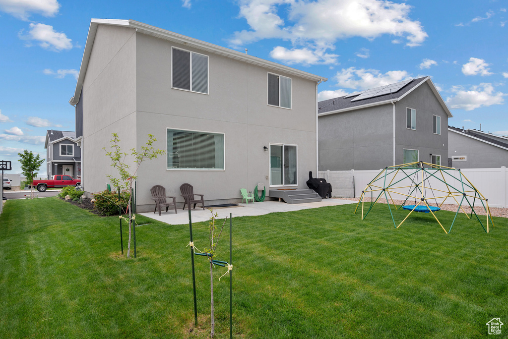 Back of property with a patio, stucco siding, and a playground