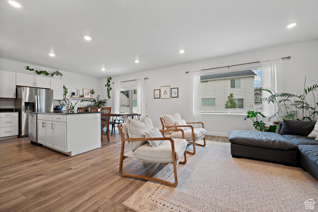 Living area with wood finished floors, recessed lighting, and baseboards