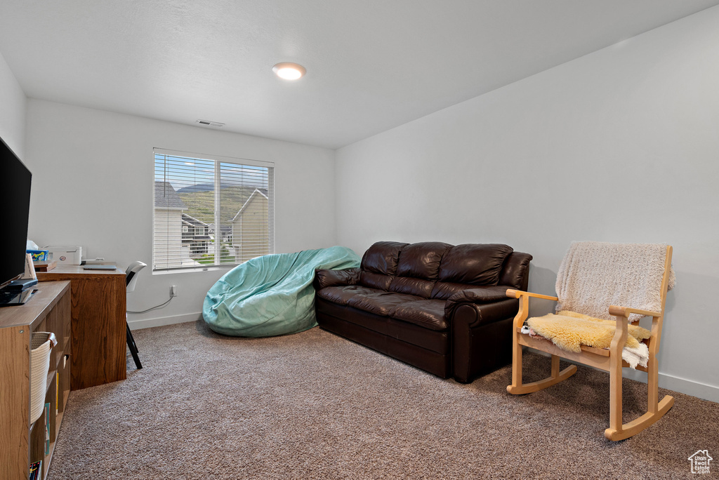 Living room featuring carpet floors, baseboards, and an office area