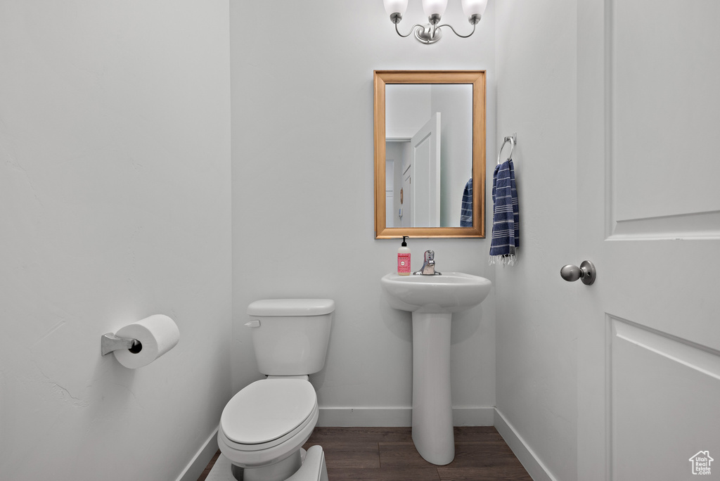 Bathroom with toilet, baseboards, and wood finished floors