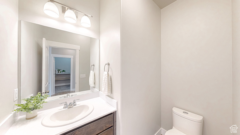 Half bath featuring toilet and vanity