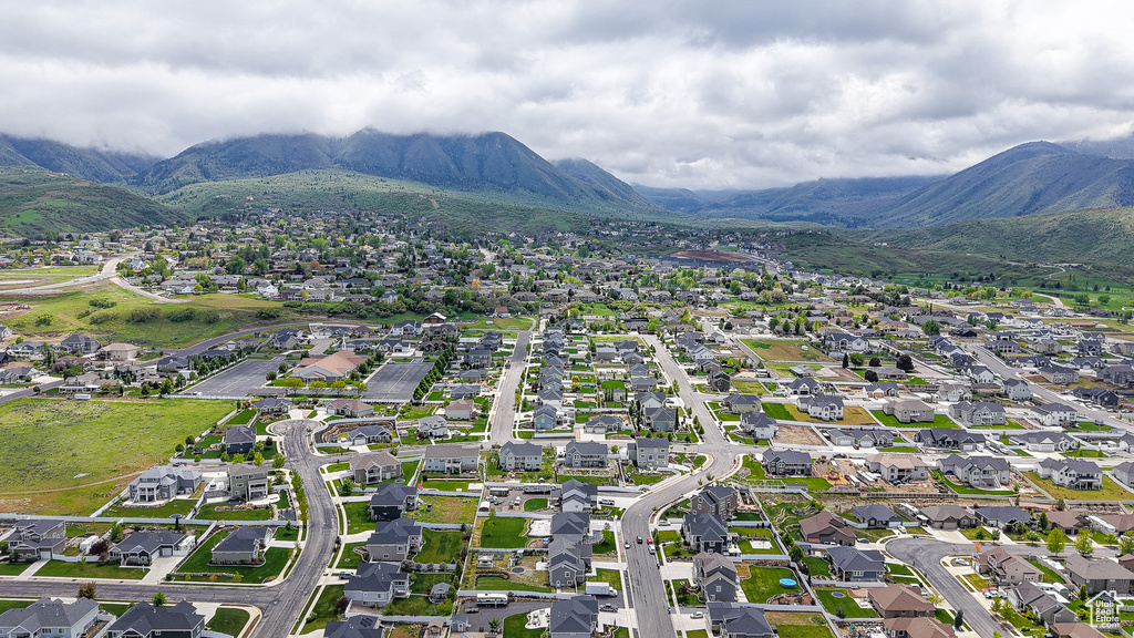 Aerial view of property and surrounding area with mountains and nearby suburban area