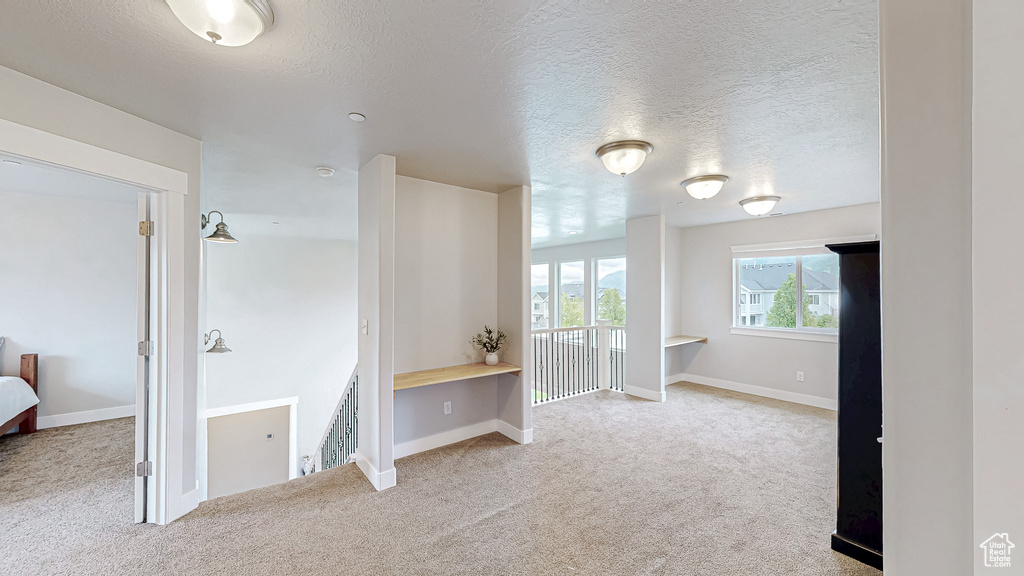 Carpeted empty room with baseboards and a textured ceiling