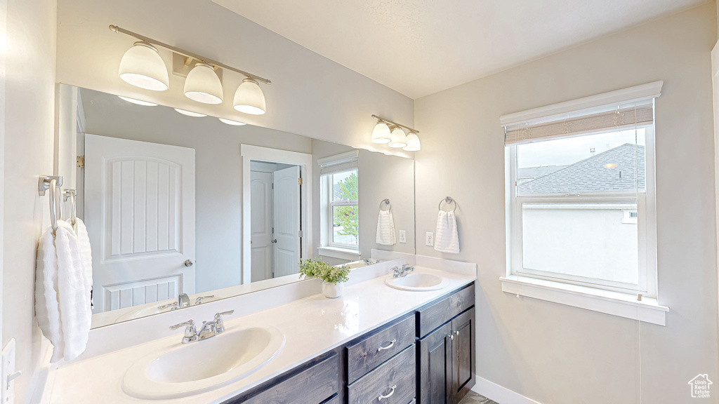 Full bath with double vanity and baseboards