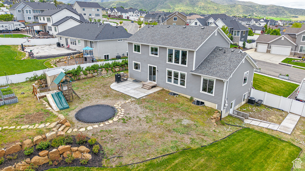 Rear view of property featuring a residential view, roof with shingles, a playground, and a patio