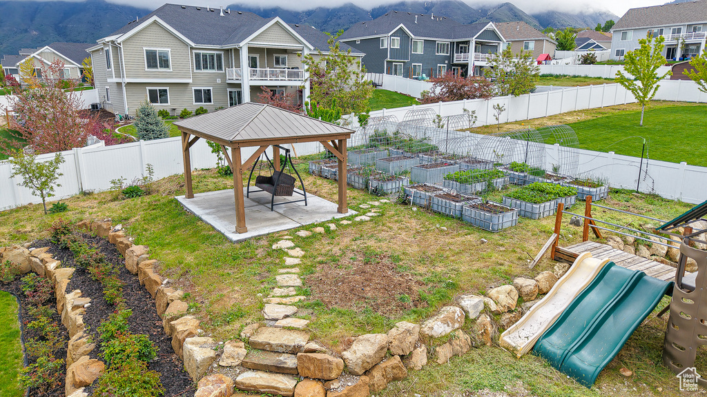View of yard featuring a gazebo, a residential view, a patio area, a vegetable garden, and a playground