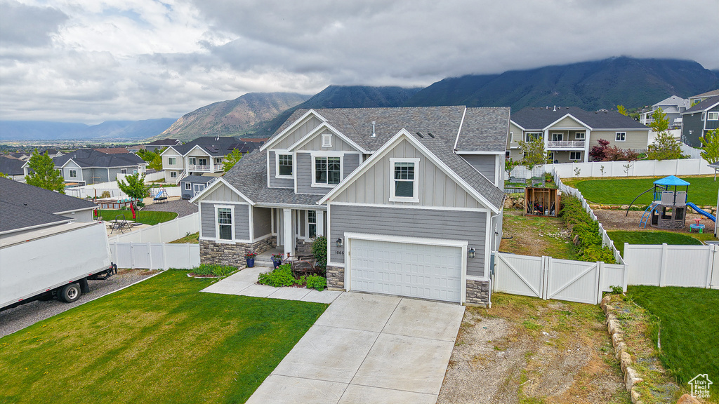 Craftsman-style house with board and batten siding, stone siding, a mountain view, and a residential view