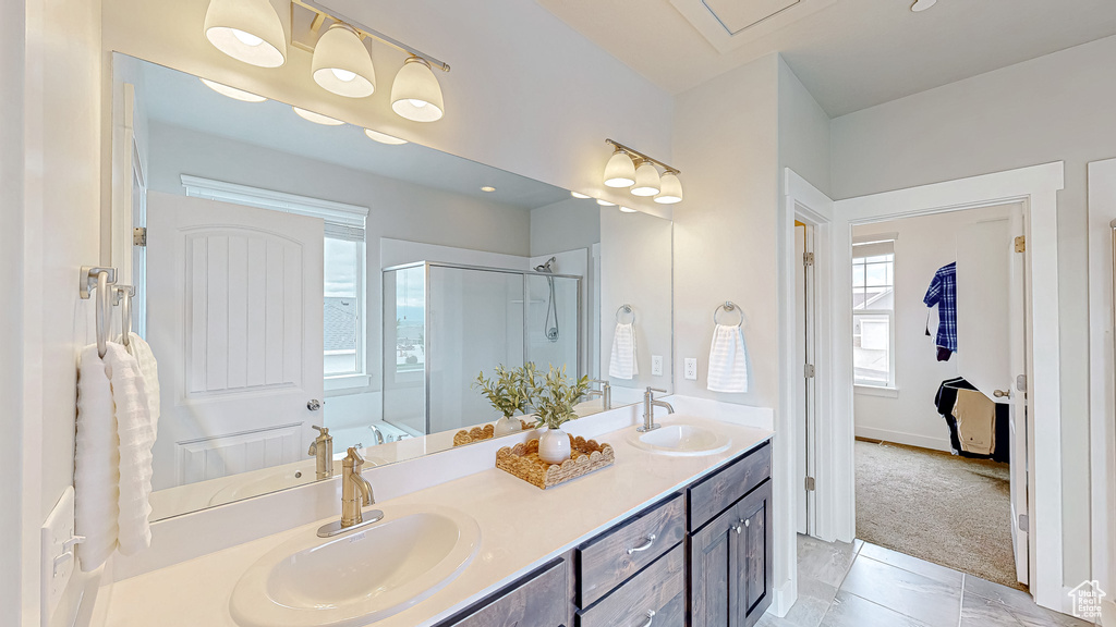 Full bathroom featuring a shower stall, double vanity, marble finish flooring, baseboards, and a tub to relax in